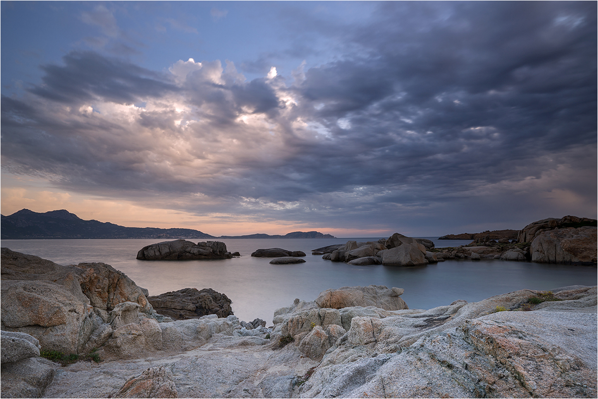 Felsen im Wasser mit Wolken obendrüber